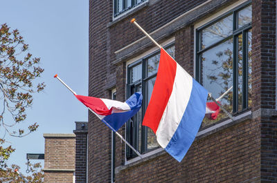 Low angle view of flag against buildings in city