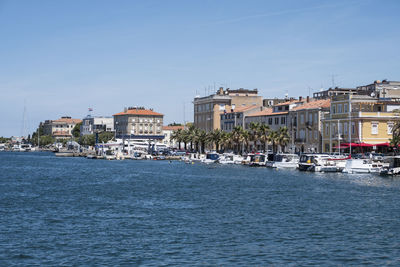 Buildings by sea against sky in city