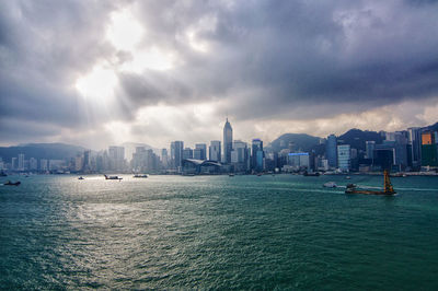 Sea by buildings against sky in city