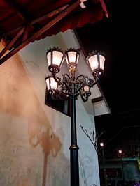 Low angle view of illuminated street light against building