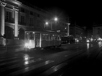 Train on illuminated street at night