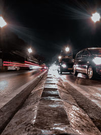 Cars on illuminated street at night