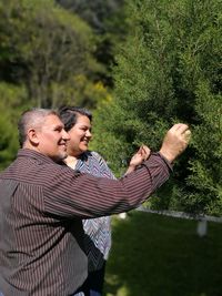 Smiling couple touching plants