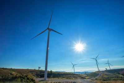 Windmill on field against clear blue sky