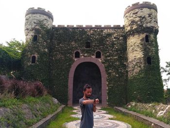 Portrait of man standing against old building