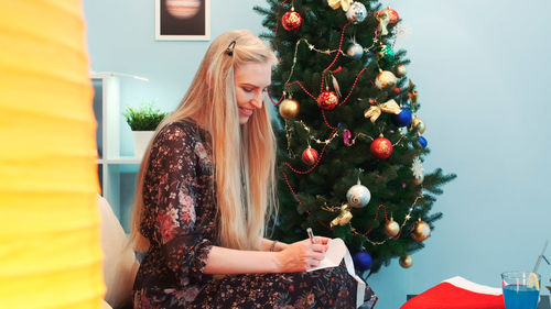 Rear view of woman with christmas tree