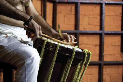 Close-up of man playing drum in india during kathakali performance 