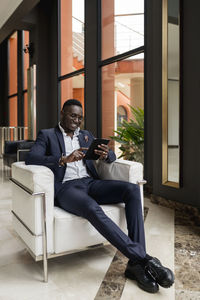 Man using mobile phone while sitting on seat