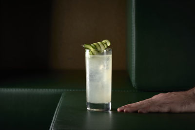 Lemonade cocktail with cucumber on green sofa