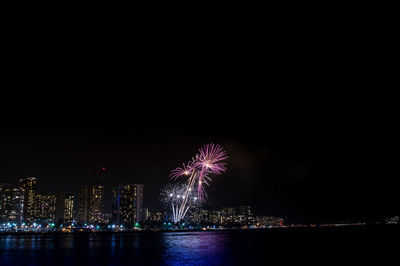 Firework display over city at night