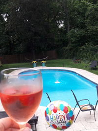 Beer in swimming pool against trees
