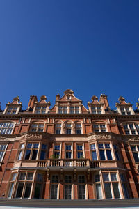 Low angle view of buildings against clear blue sky