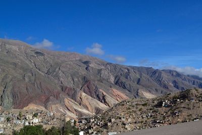 Panoramic view of landscape and mountains against blue sky