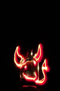 Red lit candle against black background