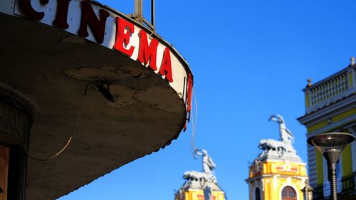 Low angle view of text on building against sky