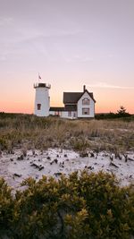 Lighthouse by sea against sky