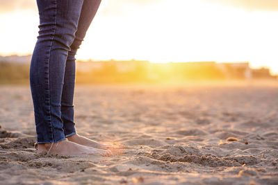 Horizontal unrecognizable woman feet in the beach at sunset. happiness summer lifestyle concept.