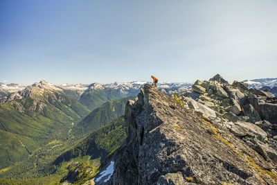 Hiker approaches mountain summit with amazing view.