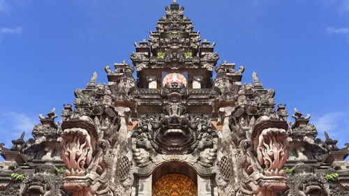 Low angle view of temple against traditional .balinese gate with intricate carvings