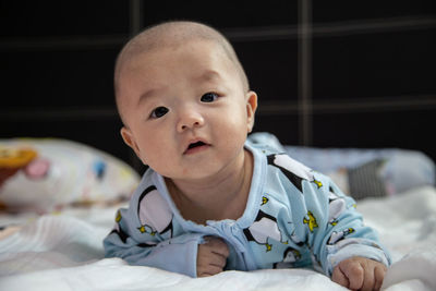 Portrait of cute baby lying on bed