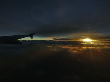 Close-up of airplane wing against sky during sunset