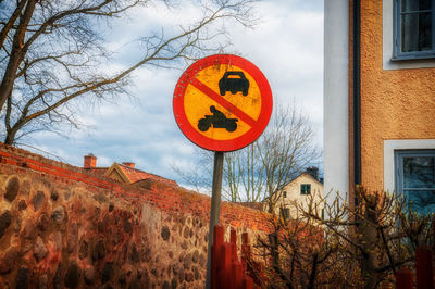 Low angle view of sign board by building against sky
