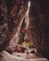 Rear view of man sitting on rock