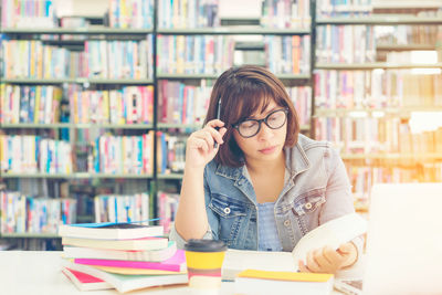 Portrait of young woman reading book