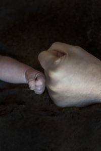 Close-up of human hand holding finger