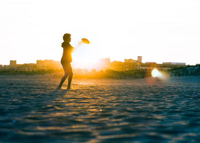 Woman standing in water against sky