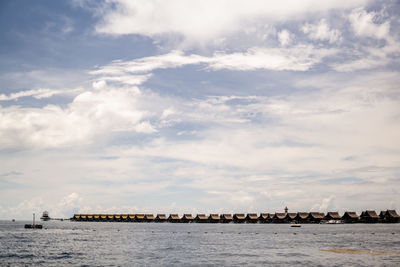 Scenic view of sea by buildings against sky