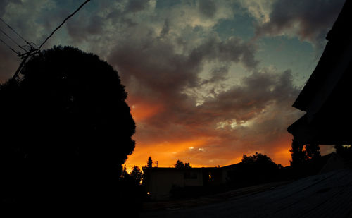 Silhouette of house against cloudy sky