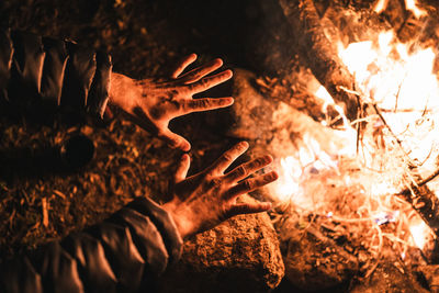Person warming hands over bonfire