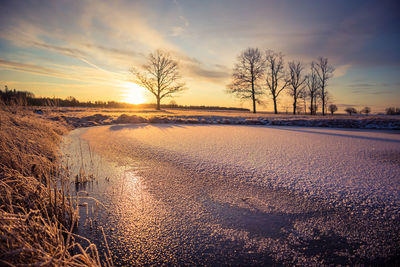 A beautiful frozen pond in the rural scene during the morning golden hour. 