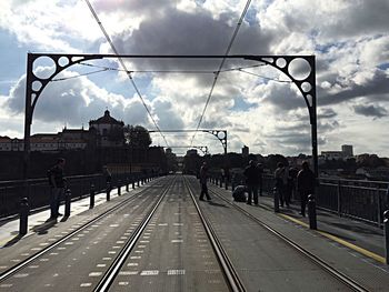 Railroad tracks against cloudy sky