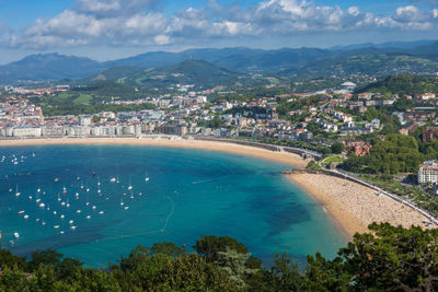 High angle view of city by sea against sky