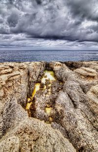 Scenic view of rocks on beach against sky