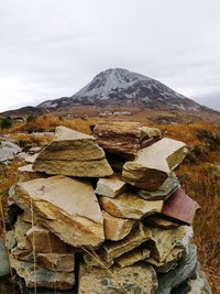 Stack of rocks on mountain against sky
