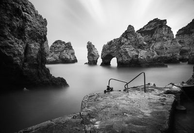 Rock formations by sea against sky