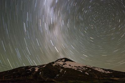 Scenic view of snowcapped mountains against sky at night