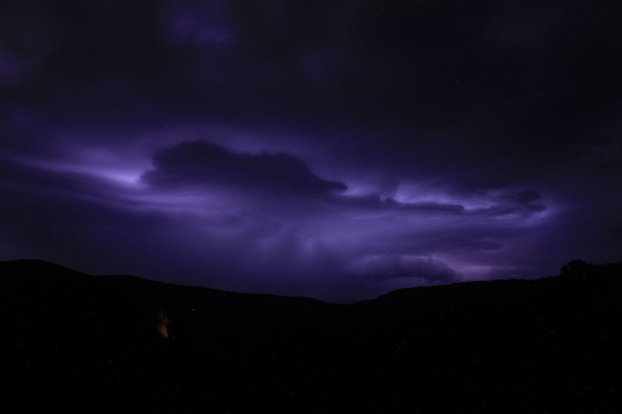 sky, cloud, night, beauty in nature, darkness, storm, power in nature, scenics - nature, mountain, thunderstorm, lightning, dramatic sky, environment, nature, dark, no people, silhouette, star, storm cloud, landscape, thunder, awe, purple, warning sign, astronomy, space, mountain range, outdoors, atmospheric mood