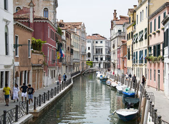 Boats in canal amidst buildings in city