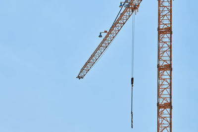 Low angle view of crane against clear sky