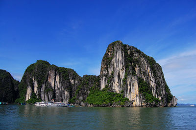 Scenic view of sea and rocks against blue sky