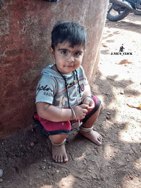 Portrait of cute boy sitting outdoors