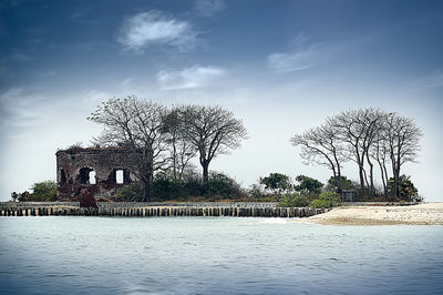 Built structure by lake against sky