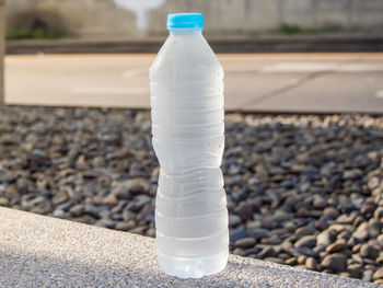 Close-up of white wine bottle on stones