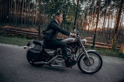 Side view of man riding a motorcycle on the road