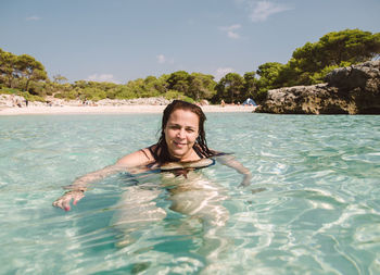 Portrait of smiling woman swimming in pool