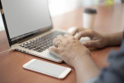 Midsection of man using laptop on table